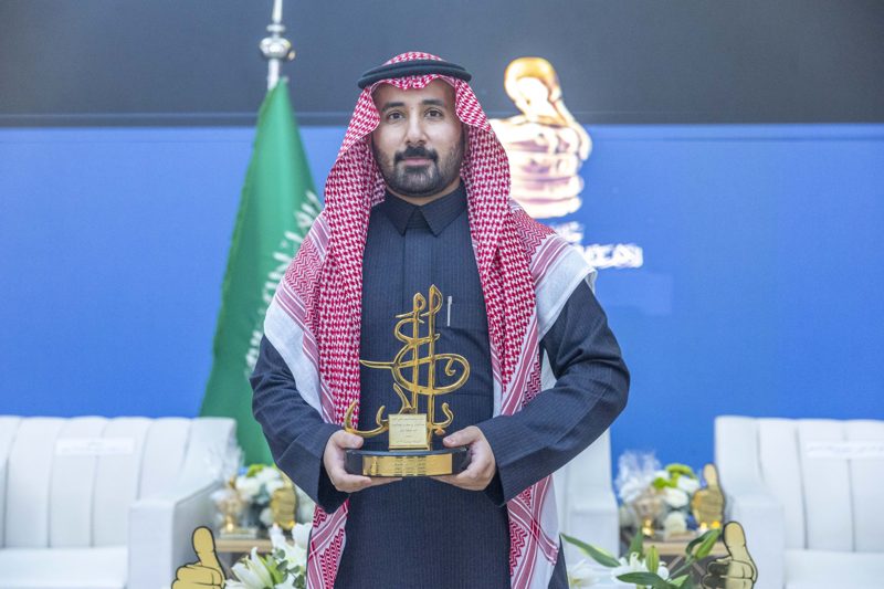 Dr. Alsaleh holding the award trophy at the 2023 ceremony